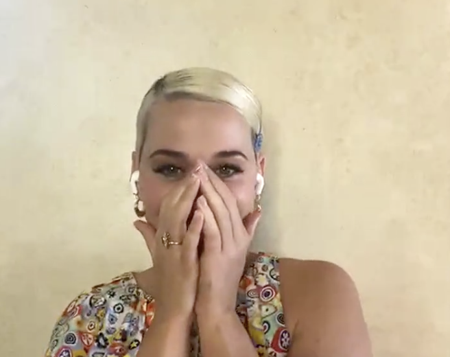 Katy holding her hands to her face in shock