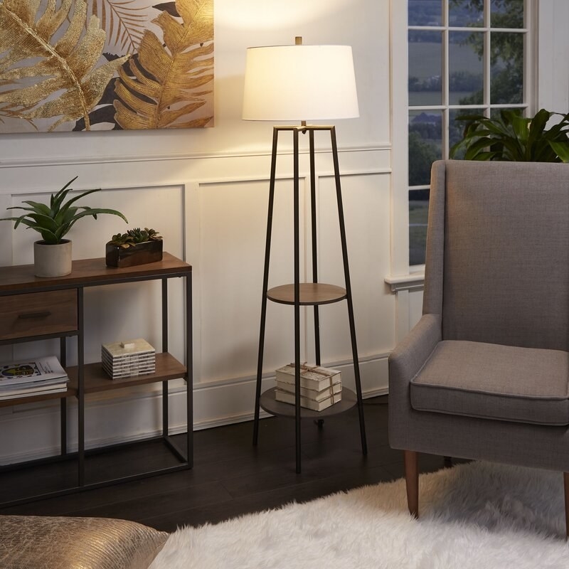 the black Bart Floor Lamp with Shelves in the corner of a living space