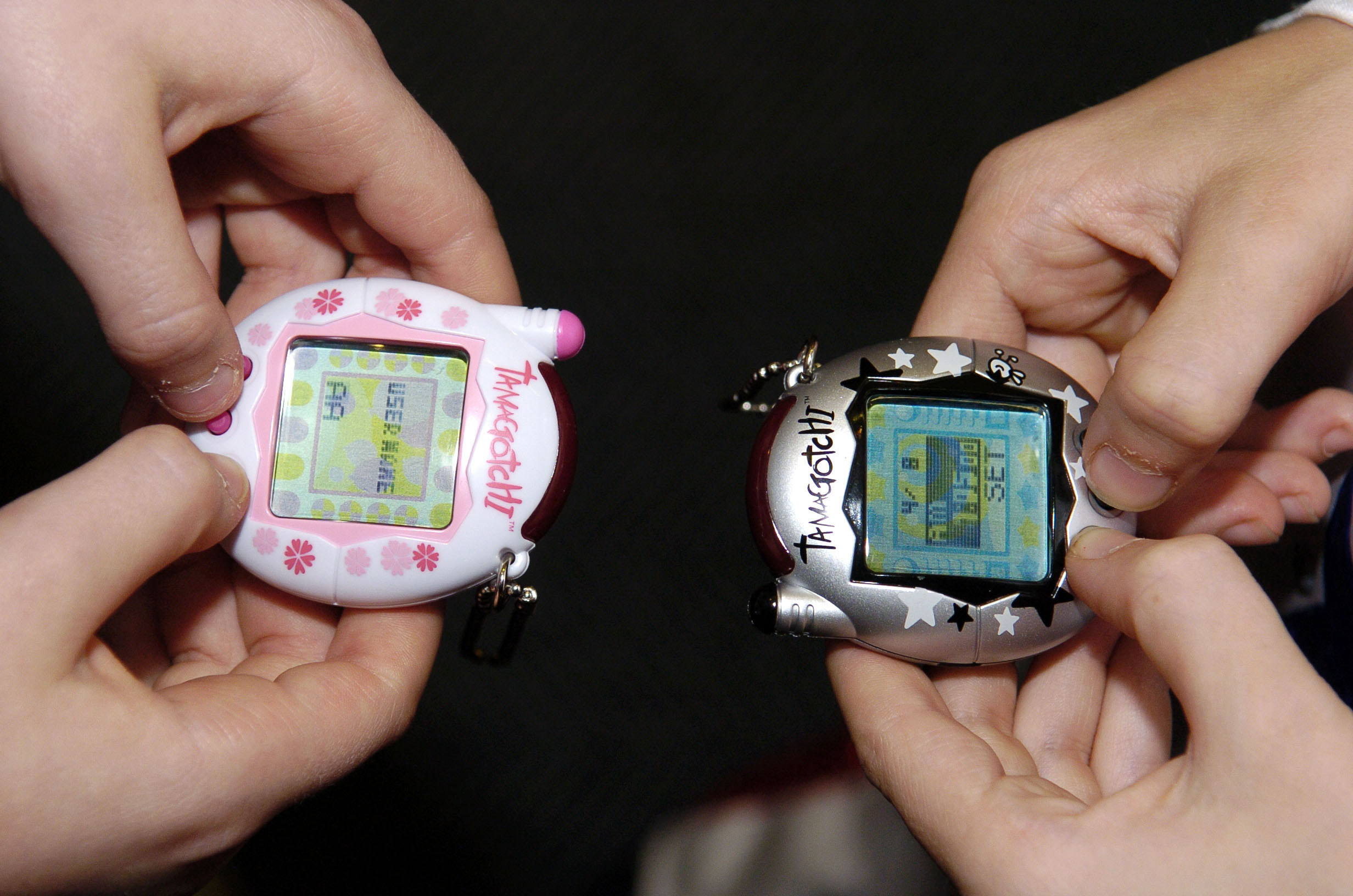 Two people set up their Tamagotchis