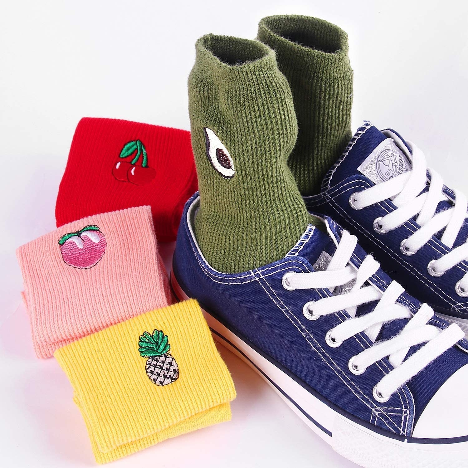 The socks with embroidered fruit on the ankles: green with avocados, red with cherries, pink with peaches, and yellow with pineapples