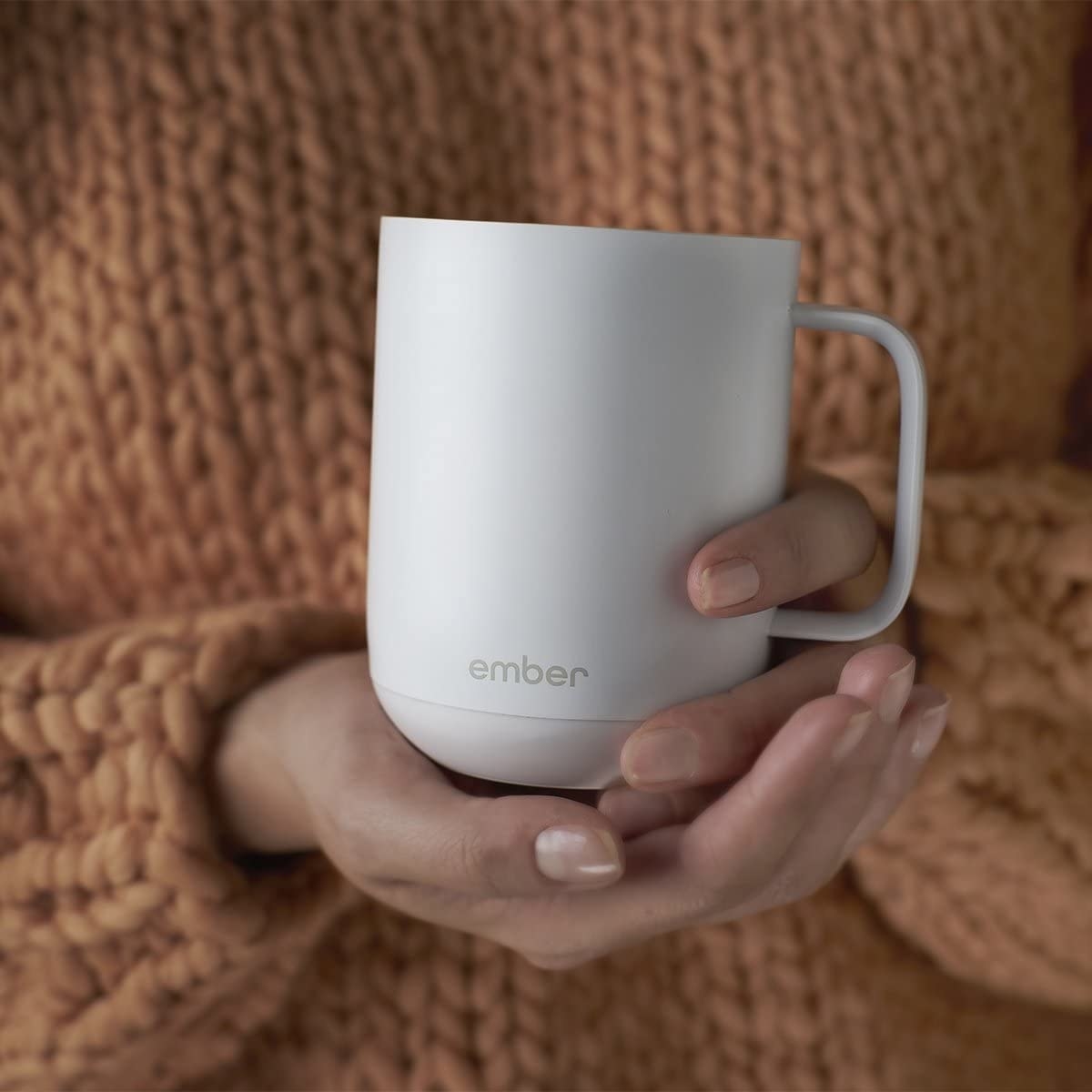 A person holding a ceramic mug