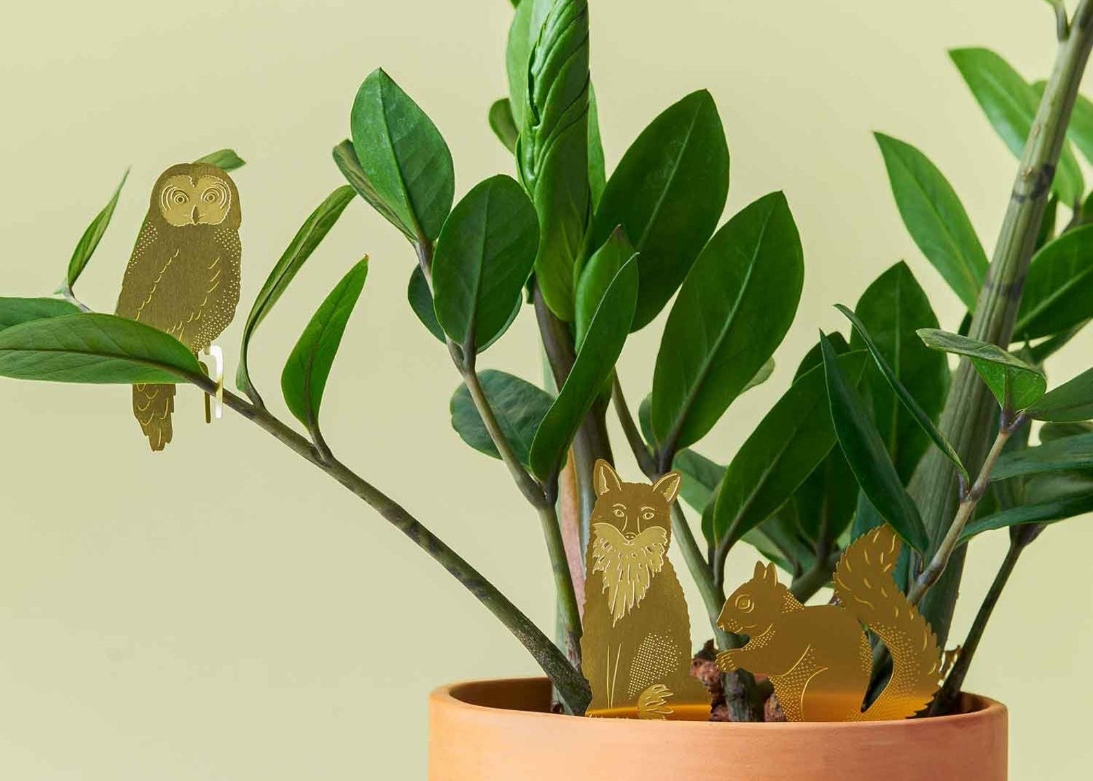 a fox, squirrel, and owl animal decoration on a plant