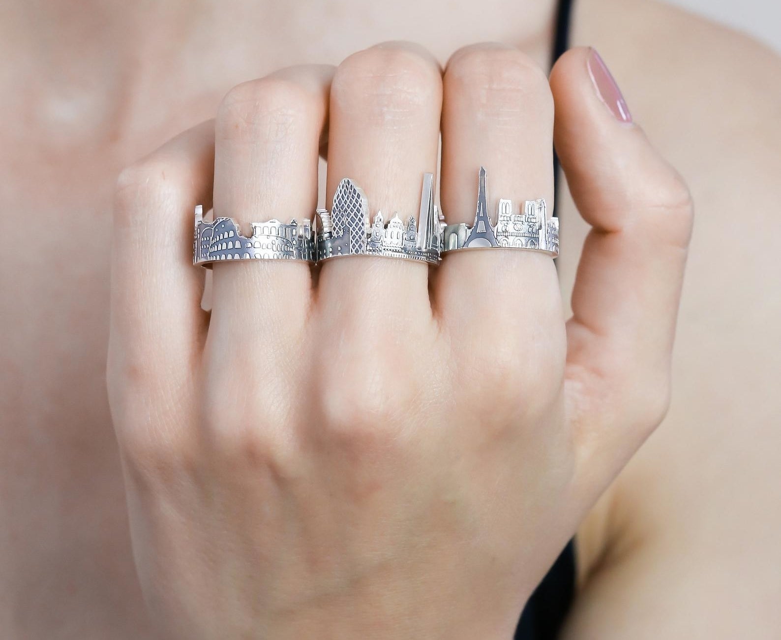 person wearing three cityscape rings