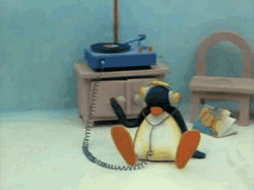 Pingu, wearing headphones hooked up to a record player, slaps the ground with his hands to the beat of the music