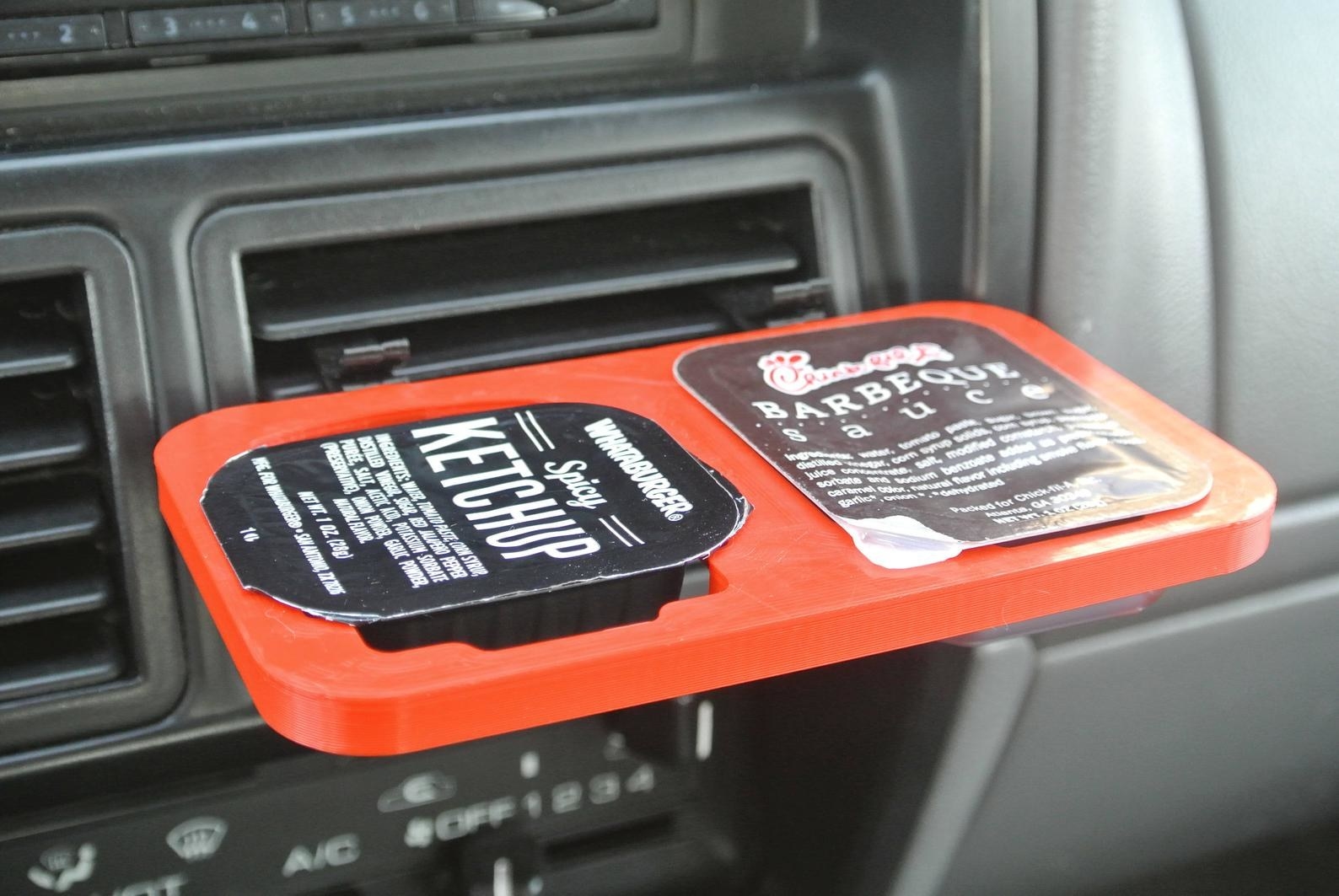 the double dipper clip holding ketchup and bbq sauce