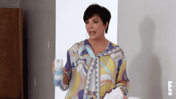 Kris Jenner spraying the room with cleaner.