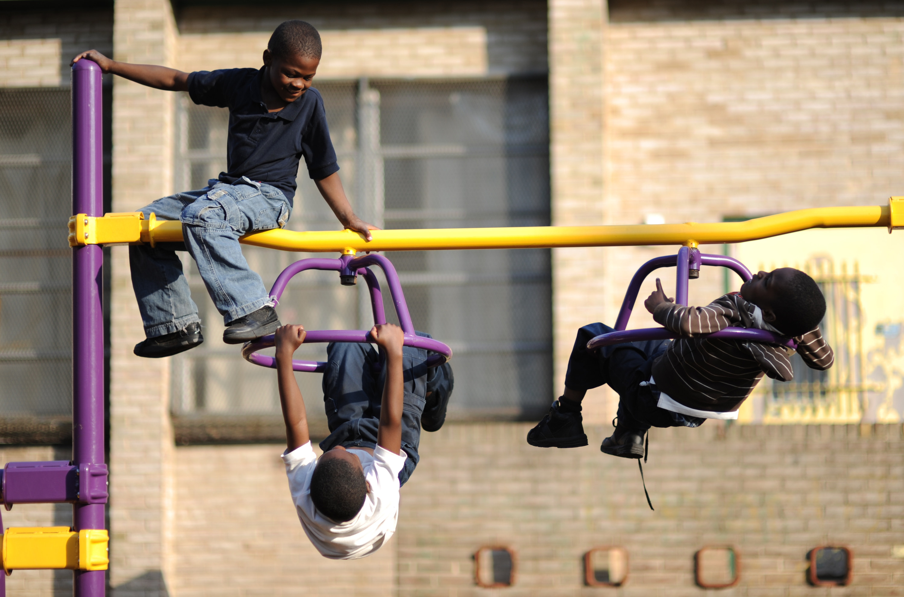 Children play on spinning monkey bars at a park