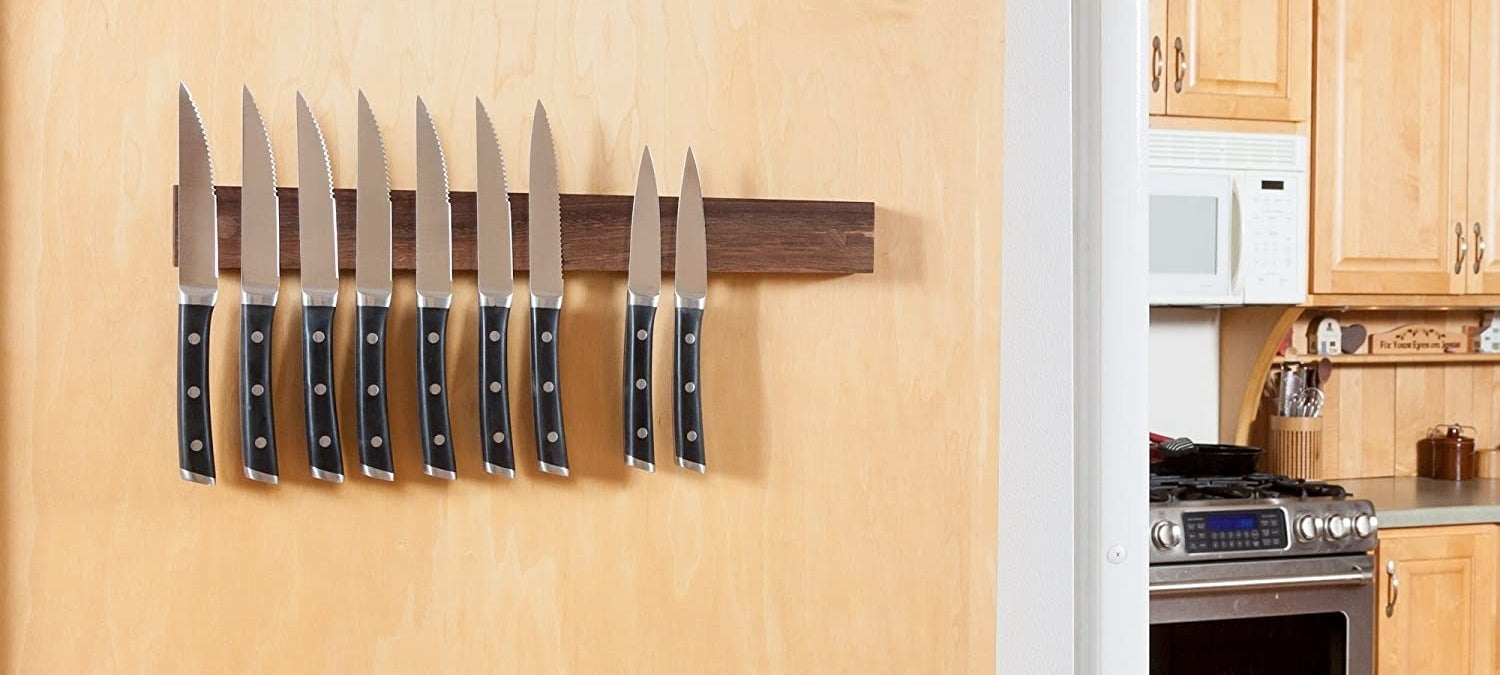 magnetic knife strip attached to a wall holding various sizes of knives