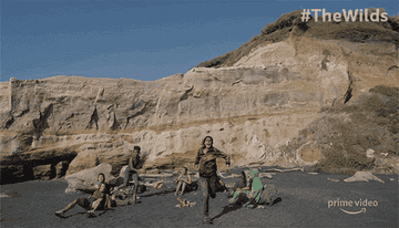 The cast of the Wilds jumping and screaming on the beach