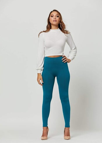 Model wearing Conceited Store Fleece-Lined Leggings in turquoise teal
