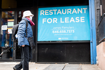 A person walks by a sign that reads "restaurant for lease"