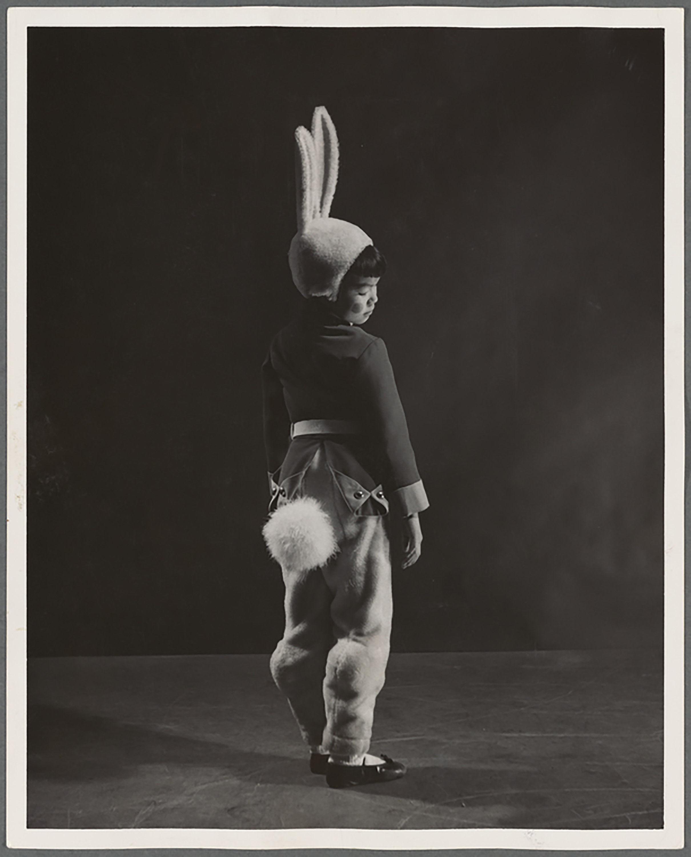 A small boy in a bunny costume with a fluffy tail