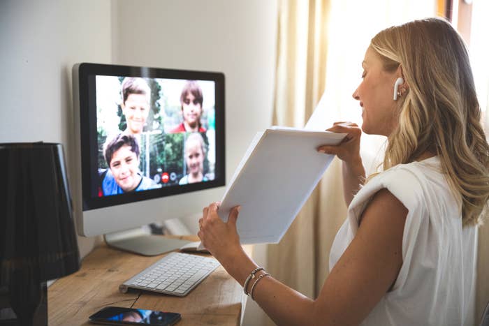 A teacher virtually teaches young students on a video call