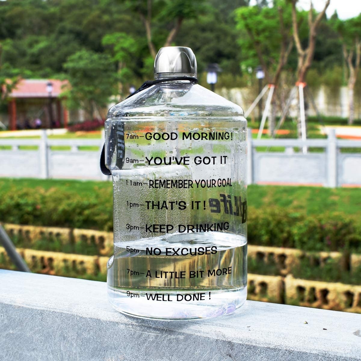A large transparent water bottle with time marking from 7AM to 9PM written on the side