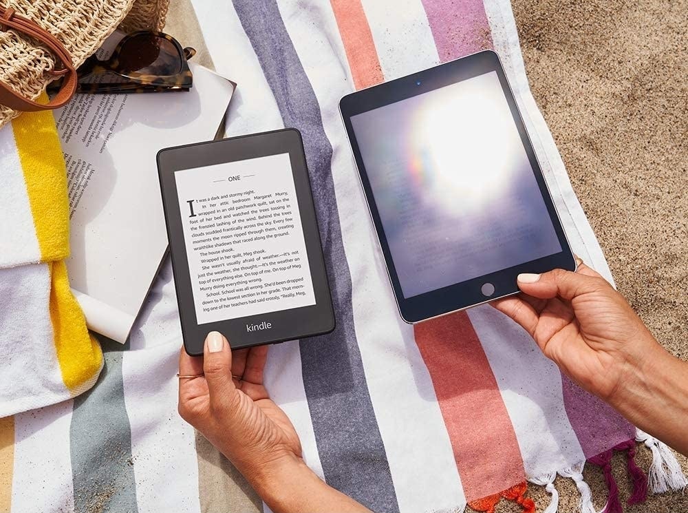 person holding the kindle next to another tablet to show that the tablet has glare