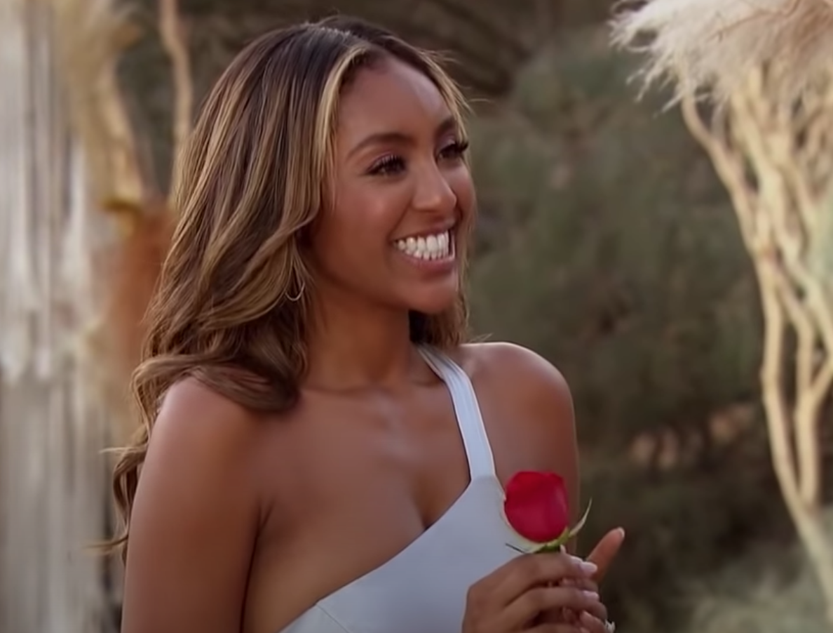 Tayshia holding a rose and smiling 