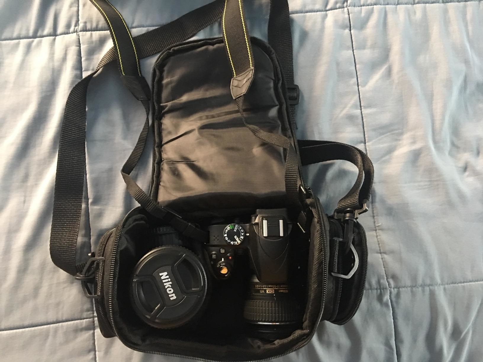 reviewer&#x27;s camera bag with a camera and extra lens inside 