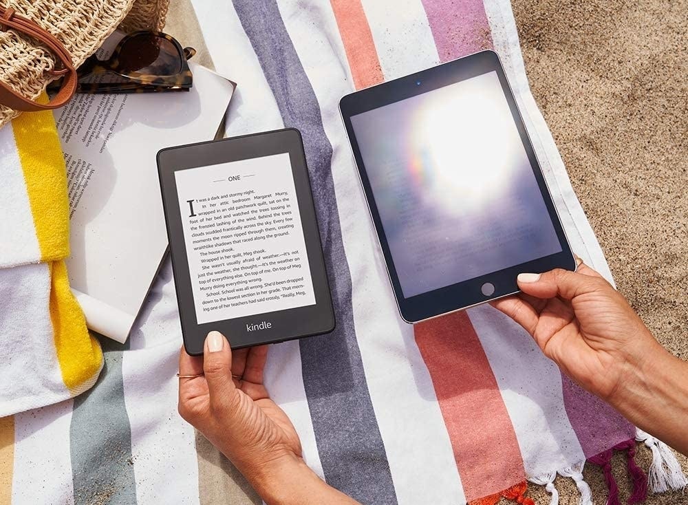 A person holding up the Kindle paperwhite next to a glaring tablet