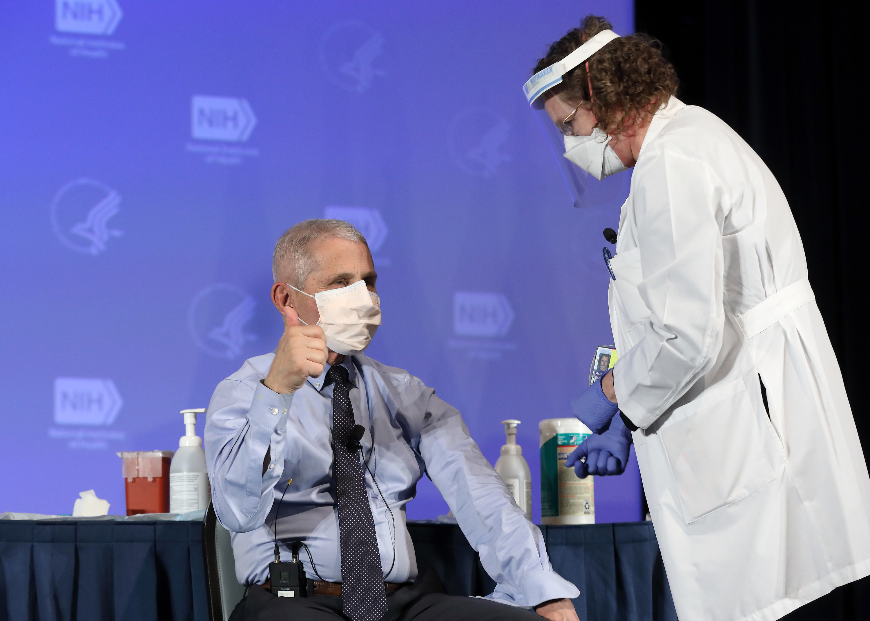 Dr Anthony Fauci gives a thumbs-up, wearing a face mask and about to receive a vaccine