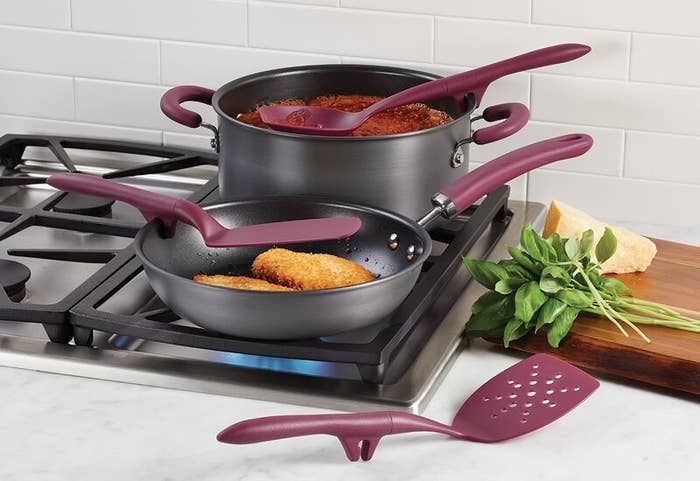 Cutting board with cheese and spinach on top beside a stove