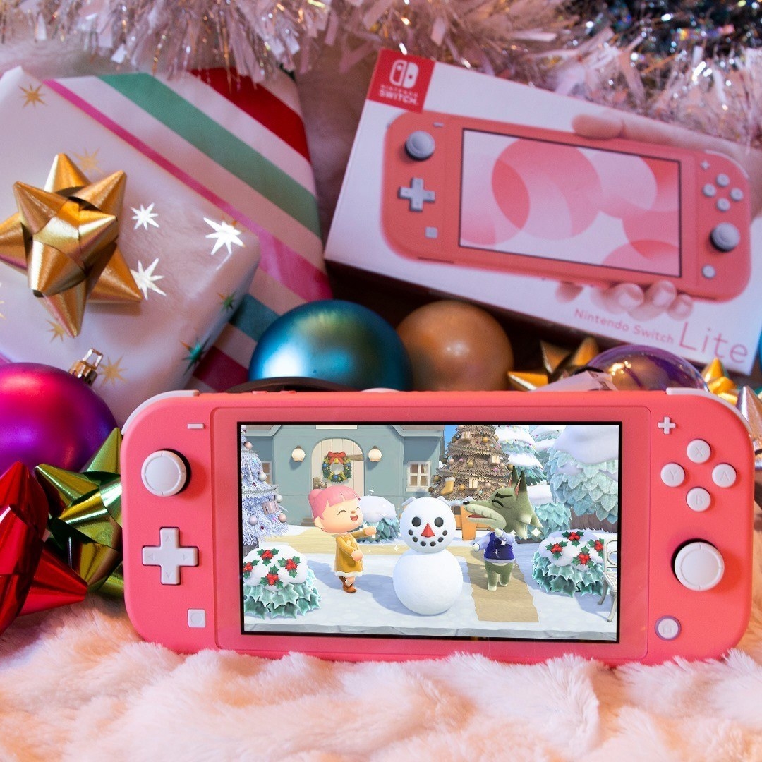 a pink nintendo switch lite with animal crossing on the screen