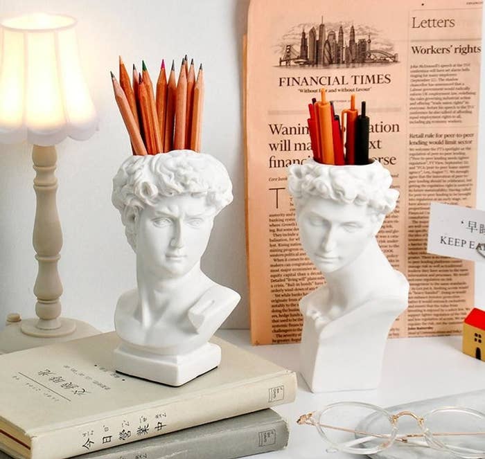 two stylish david pen holders on a desk holding pens and pencils