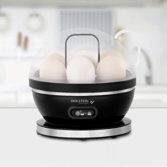 An egg cooker with several eggs inside