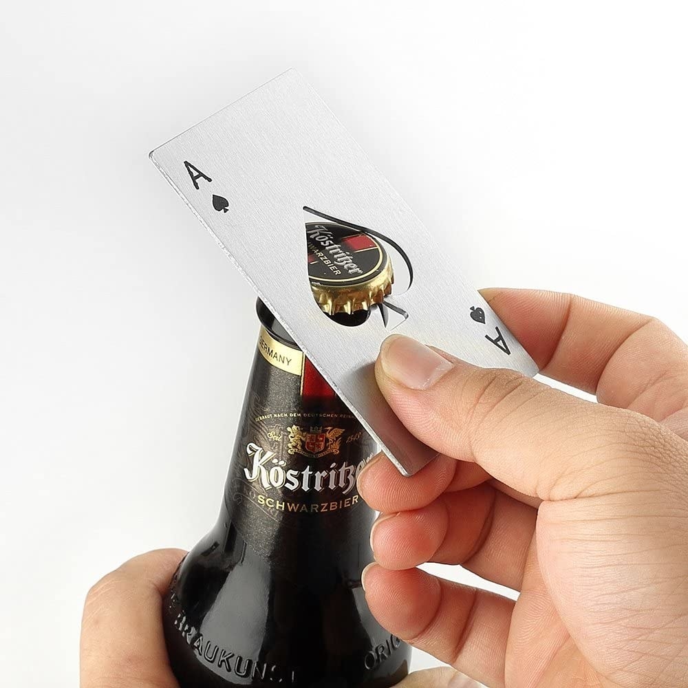 A model popping a cap off a bottle with an ace of spade-shaped bottle opener 