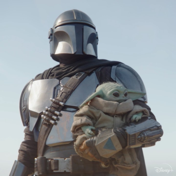 The Mandalorian holding Baby Yoda