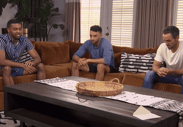 The remaining three men sit awkwardly in a room