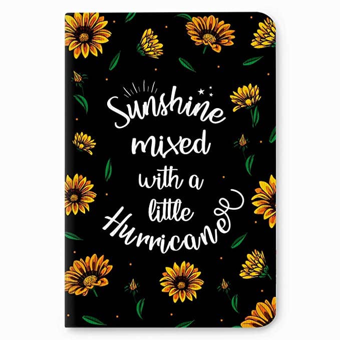 Black notebook with sunflowers and the words ‘Sunshine mixed with a little hurricane’ written on it.
