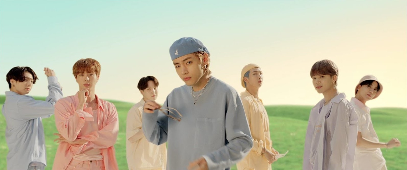 BTS wear colorful clothes and pose in a field in the Dynamite music video