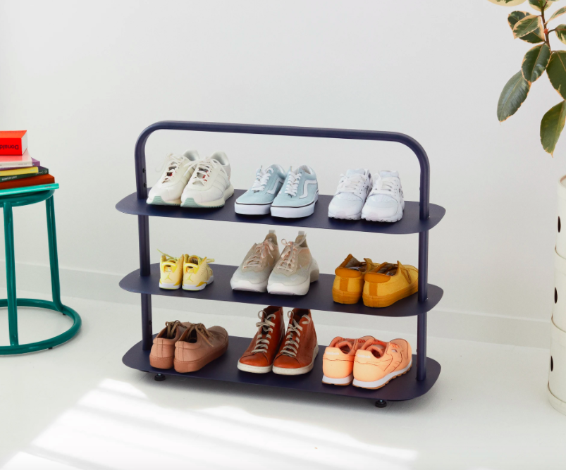 Three-tiered blue shoe rack with nine pairs of shoes displayed