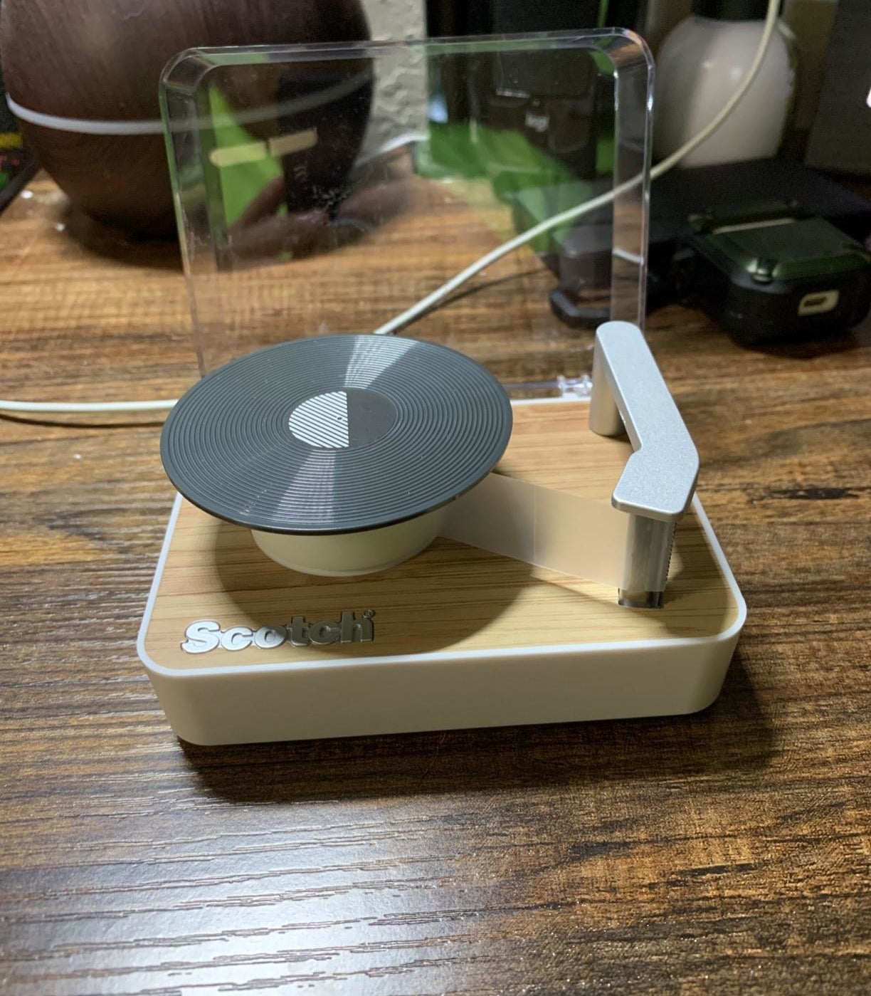 tape dispenser with the roll on the record part and the end of the tape stuck to the needle part, there&#x27;s even a cover that goes up and down 