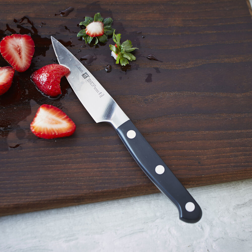 paring knife on cutting board next to sliced strawberries 