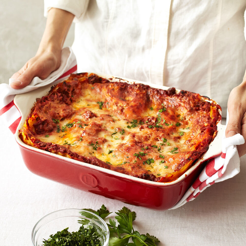 model holding a dish of lasagna 