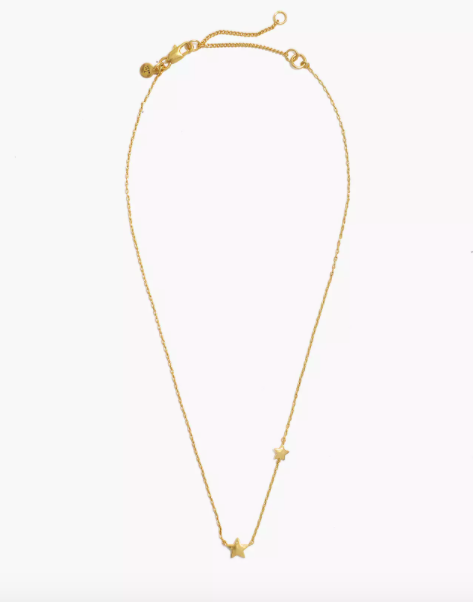 gold tone necklace with two star charms on it
