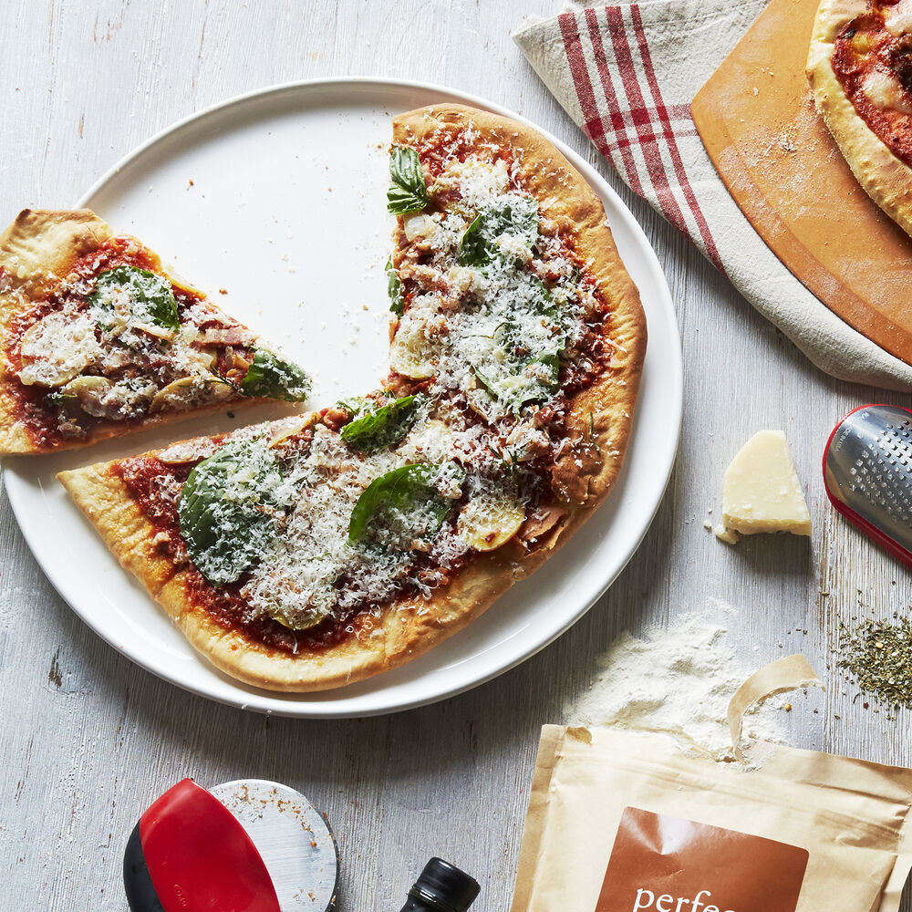 round cheese platter with a pizza on it 