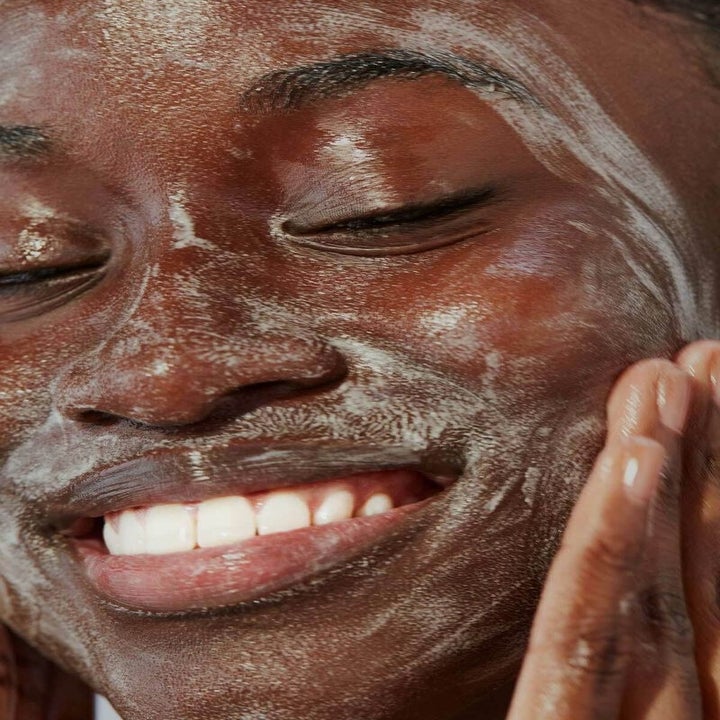 Model rubbing the cleanser on their face