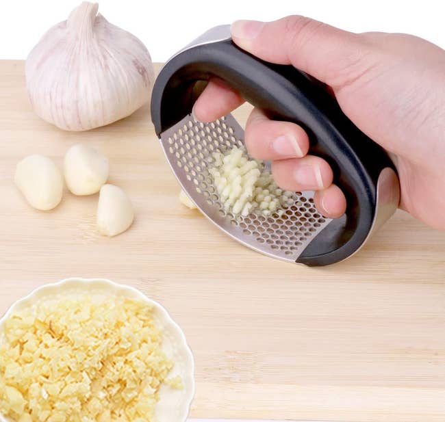 model holding the rolling handheld garlic press