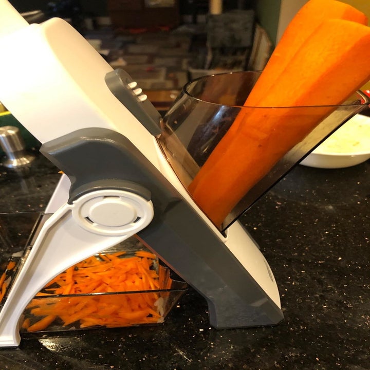 a reviewer shredding carrots with the mandolin