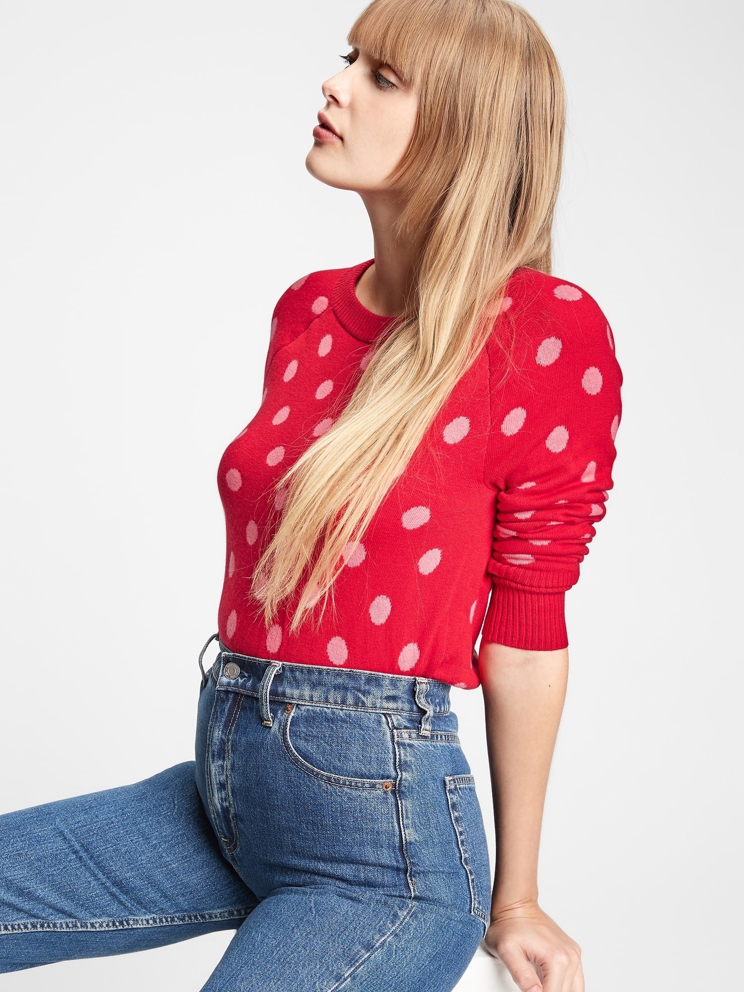 a model in a red sweater with white polka dots