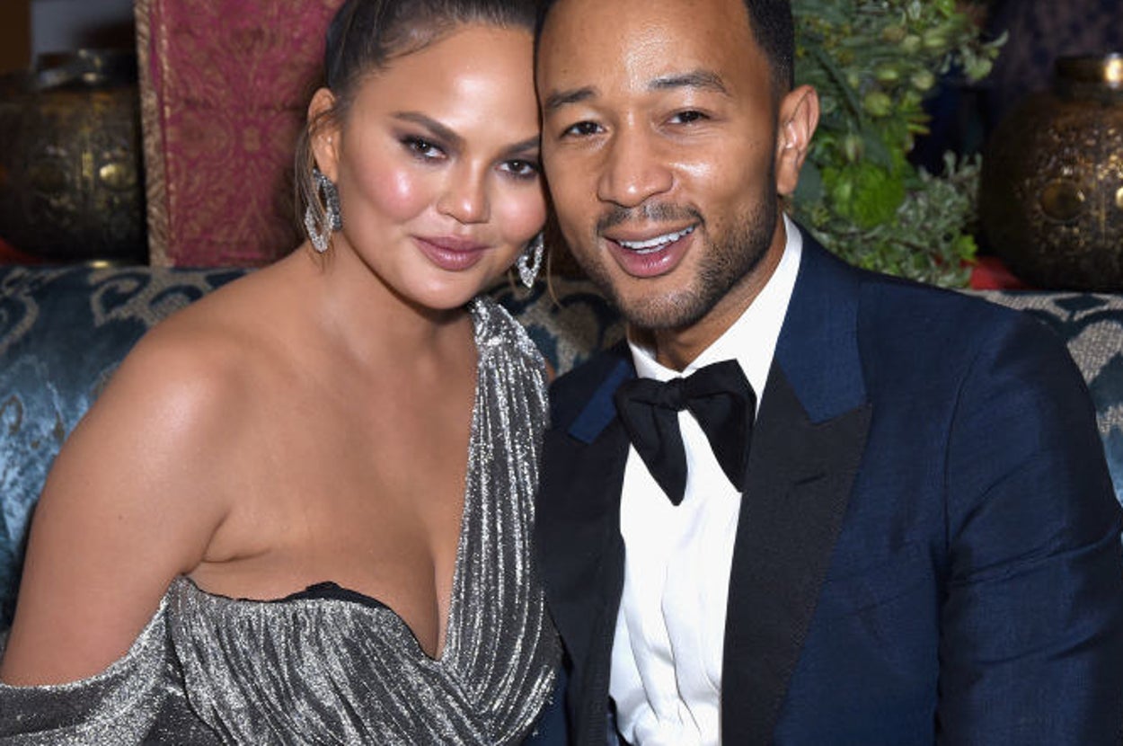 Chrissy Teigen and John Legend smiling together at a press event