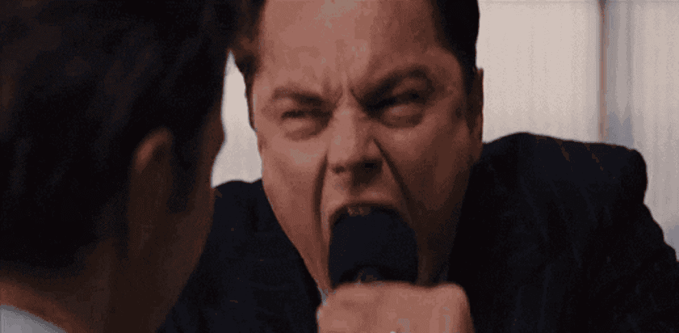 Gif of Jordan Belfort from Wolf of Wall Street yelling into a microphone and angrily walking away 