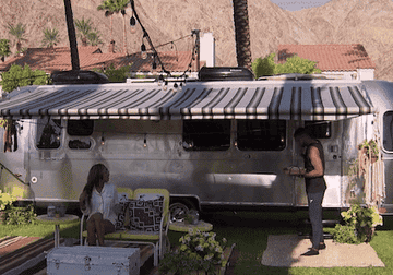 Ivan exits an RV with breakfast