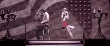 a gif of gary lightbody and taylor swift singing &quot;the last time&quot; from an official red tour video