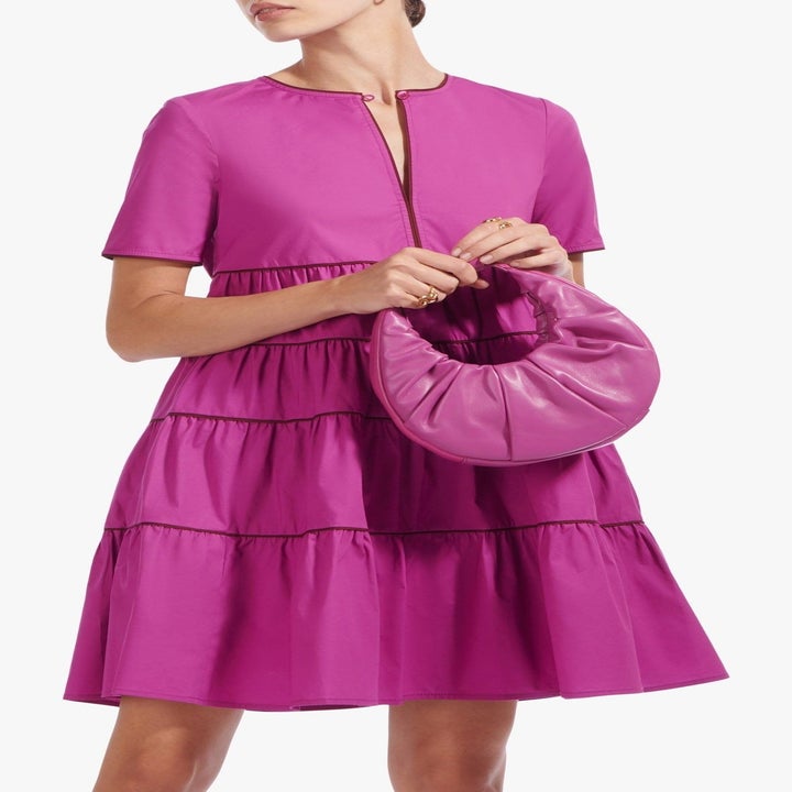 model in fuschia dress with matching bag
