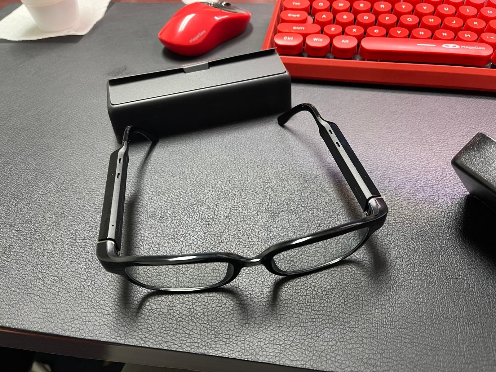 reviewer photo of Echo frames resting on a desk next to their included case