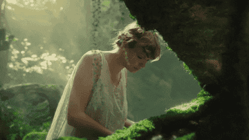 a gif of taylor swift playing the piano in the &quot;cardigan&quot; music video