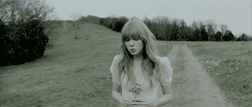 a gif of taylor swift walking and singing in the &quot;safe &amp; sound&quot; music video